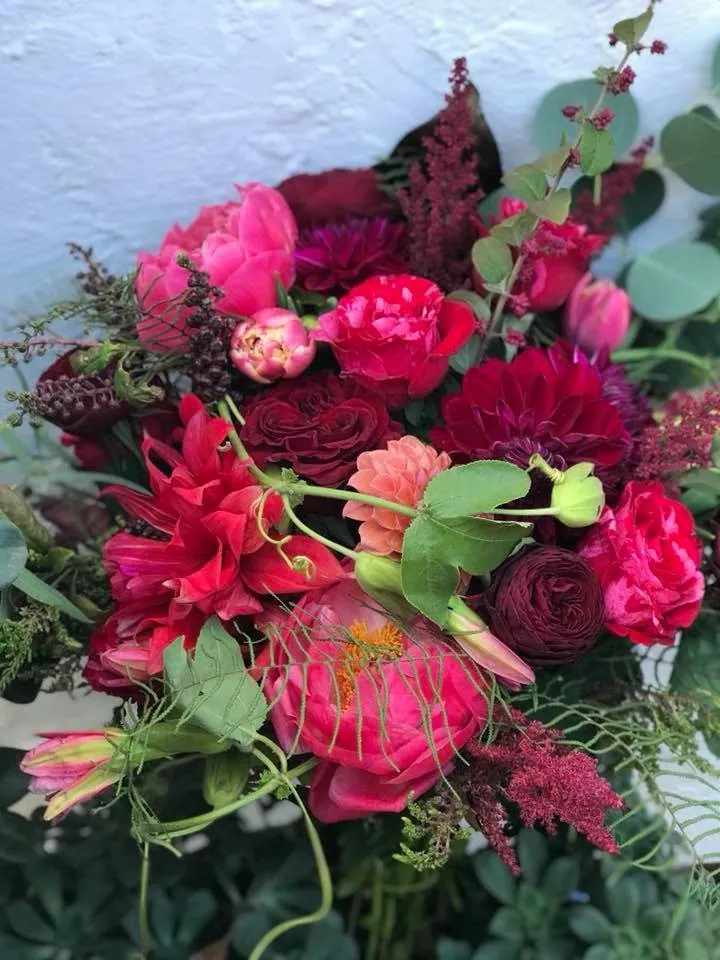 Hot pink, red, and green bouquet with bold color.