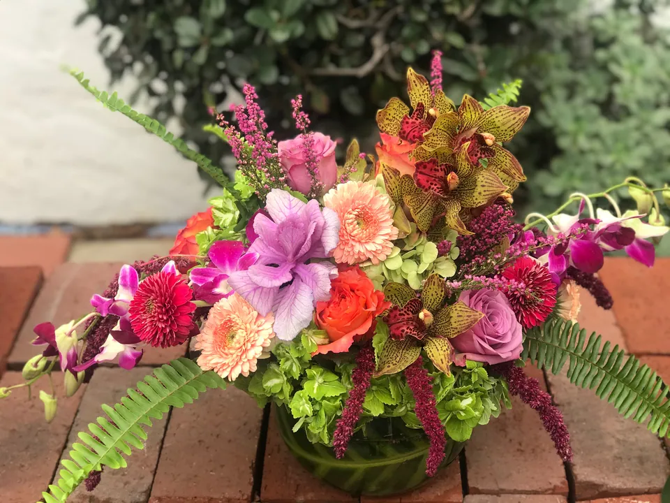 Low garden bowl with magenta, peach, pink, yellow, and green flowers by Margaret Rose Floral Design in Long Beach.
