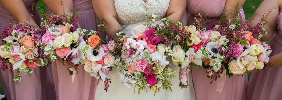 Long wedding table floral runner with pink, white, and green flowers.